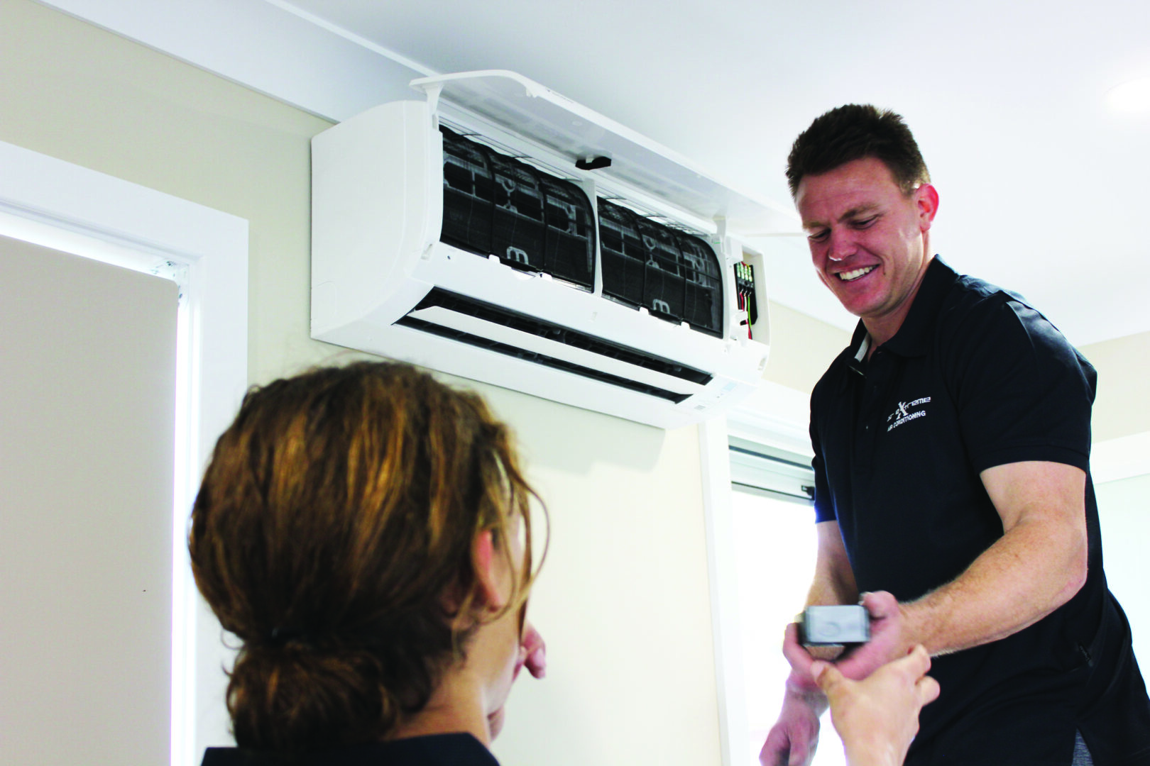 Air Extreme technician servicing an air conditioner